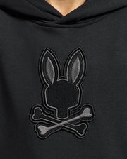 Meet the KIDS NEW CASTLE EMBROIDERED FRENCH TERRY HOODIE by Psycho Bunny: a black hoodie featuring an embroidered bunny with long ears atop crossed bones, presenting a stylish twist on the skull and crossbones design.