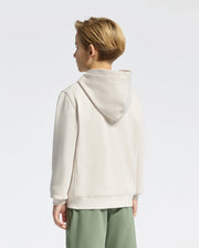 A person with short hair wears a KIDS LEVY ESSENTIAL ZIP FLEECE HOODIE - B0H720D200 by Psycho Bunny in cream and light green pants, standing against a plain white background.