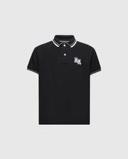 The KIDS ELLIOT PIQUE POLO - B0K505F200 by Psycho Bunny is a black polo made from soft Pima cotton, highlighted with white and tan trim on the collar and sleeves, featuring a playful embroidered Bunny on the left chest, elegantly displayed against a light gray background.