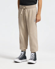 A person is wearing Psycho Bunny's KIDS LEVY ESSENTIAL FLEECE SWEATPANT with a drawstring and small leg design, paired with black high-top sneakers and a black top, all set against a white background.
