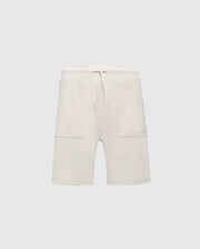 The Psycho Bunny KIDS TAYLOR LIGHT PIQUE SWEATSHORT (B0R344F200) features a cream-colored, Pima cotton design with a drawstring waist and two large front pockets, offering soft comfort and adding casual-chic style to any wardrobe. Perfect for an effortlessly stylish everyday look.
