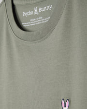 A green KIDS CLASSIC CREW NECK TEE - B0U014B200 by Psycho Bunny features a pink and white embroidered bunny skull logo on the lower side. Made from 100% Pima cotton, it's ideal for back-to-school outfits, with size info in white text on the inner back neck.