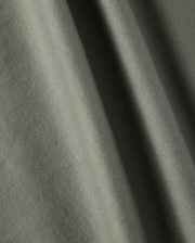 Close-up of a textured olive-green fabric with soft folds, showcasing the material's subtle creases and smooth surface, reminiscent of the Psycho Bunny KIDS CLASSIC CREW NECK TEE - B0U014B200, perfect for back-to-school outfits.