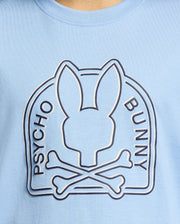 The Psycho Bunny KIDS MELBOURNE GRAPHIC TEE (B0U410F200) in light blue showcases a stylized bunny head above crossed bones with the text "Psycho Bunny." Made from 100% Pima cotton, it is soft and eco-friendly.