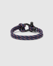 The Psycho Bunny MEN'S ROPE BRACELET - B6A368E200 features a stylish braided navy nylon design with red and white accents and a sleek black metal clasp, elegantly presented on a light gray background, capturing the essence of lightweight men's accessories.