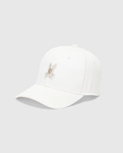 The Psycho Bunny MENS NEW CASTLE EMBROIDERED GRAPHIC BASEBALL CAP - B6A547F200 showcases a beige rabbit embroidery on a white cotton twill, offering an essence of quiet luxury against a plain gray background.