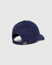 The Psycho Bunny MENS CLASSIC BASEBALL CAP - B6A816A1HT in classic navy blue is shown from the back, highlighting its six-panel cotton twill construction. It includes a curved brim and an adjustable metal strap for sizing, elegantly placed on a plain, light gray surface.
