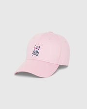 The MENS CLASSIC BASEBALL CAP - B6A816A1HT by Psycho Bunny is a timeless pink accessory made from six-panel cotton twill. It prominently features the brand's iconic black and white embroidered Bunny logo, showcasing a cartoon rabbit head and crossed bones. The cap is elegantly showcased on a plain white background.