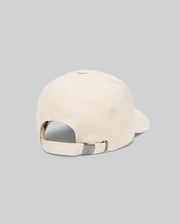 The Psycho Bunny MENS CLASSIC BASEBALL CAP (B6A816A1HT) in cream cotton is shown from the back, highlighting its adjustable strap with a metallic clasp against a plain gray background.
