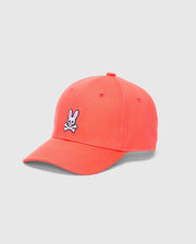 The Psycho Bunny MENS CLASSIC BASEBALL CAP - B6A816F200 is bright pink, made from cotton twill, and showcases a white bunny with crossed bones embroidered on the front. It features an adjustable fit and is set against a plain light gray background.