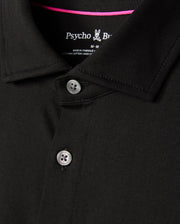 Close-up of a black MENS ARTHUR JERSEY SHIRT - B6C748D200 collar and upper chest area, featuring two buttons slightly undone. The brand "Psycho Bunny" is visible on the inside of the collar, along with the size "M." The stitching and jersey fabric texture in stretch Pima cotton are clearly depicted.