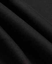 Close-up of black fabric revealing its woven texture and soft sheen, evocative of a high-quality jersey. The material appears smooth and slightly folded, suggesting the stylish warmth you'd expect from the Psycho Bunny Mens James Premium Zip Hoodie - B6H793D200.