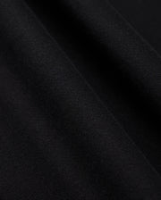 Close-up image of black fabric with a slight texture and soft folds. The surface appears smooth with fine, even weave, showcasing the material's quality and depth. Perfectly suited for a Psycho Bunny Men's Levy Fleece Hoodie (B6H859D200), crafted from 100% cotton for comfort and durability.