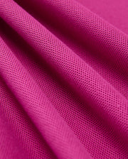 A close-up of a pink textured fabric, featuring its detailed weave and vibrant color, crafted from 100% Pima cotton, introduces the Mens Classic Pique Polo Shirt - B6K001D200 by Psycho Bunny.