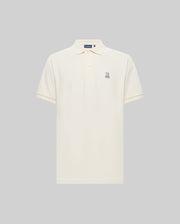 The Psycho Bunny MENS CLASSIC PIQUE POLO SHIRT (B6K001F200) in cream is made from soft Pima cotton, featuring short sleeves, a collar with three buttons, and an embroidered Bunny logo on the left chest. Shown against a light gray background.