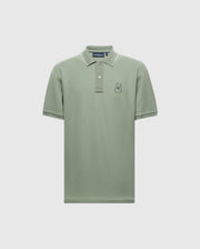 Explore the Psycho Bunny MENS NEW CASTLE PIQUE POLO in light green with white trim on the collar and sleeves. Made from soft Pima Cotton, it has a small embroidered rabbit on the left chest and a classic button-up neckline, offering luxurious details against a pristine white backdrop.