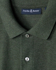 Close-up of a green Psycho Bunny MENS JAMES PREMIUM PIQUE POLO SHIRT - B6K945D200, showcasing its lightweight pima cotton fabric, collar, two buttons, and the brand label on the inner collar.