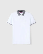 A white Pima cotton polo shirt with a gray collar and diamond knit trim on the sleeves, featuring a subtle embroidered Psycho Bunny logo on the chest and a buttoned placket. The background is plain gray. This product is known as the Psycho Bunny Men's Malton Pique Polo Shirt - B6K950D200.