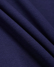 Close-up of folded fabric from the Psycho Bunny Men's Kent Pique Polo Shirt (B6K951D200) in dark blue, highlighting its textured, knit-like surface and stylish detail.
