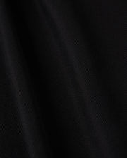 Close-up of the black Pima cotton fabric from the Psycho Bunny MENS KENT LONG SLEEVE PIQUE POLO - B6M935D200, featuring a soft texture and subtle diagonal lines that enhance its depth and smoothness. The material offers a velvety touch with a slight sheen under light, embodying quiet luxury with its rich, dark tone.