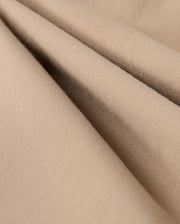Close-up of beige fabric with a soft, smooth texture and subtle folds. The material appears lightweight and finely woven, suggesting it could be used for clothing or upholstery. The color and texture give a cozy and comfortable impression, making it perfect for the Psycho Bunny MENS LLOYD CARGO JOGGER - B6P159B200's snap fastening pockets.