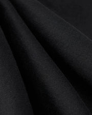 Close-up image of the MENS LEVY ESSENTIAL FLEECE SWEATPANT - B6P721D200 by Psycho Bunny in black fabric, highlighting its smooth texture and soft folds. The tightly woven material with a slight sheen suggests it is perfect for high-quality cotton sweatpants.