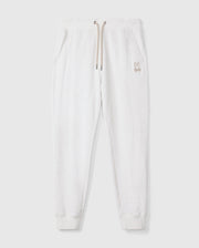The MENS JAMES PREMIUM SWEATPANT - B6P791D200 by Psycho Bunny delivers ultimate comfort with its light gray cotton-blend fabric, featuring an elastic waistband, drawstring, and side pockets. A small rabbit logo is elegantly embroidered on the upper left side. These sweatpants have ribbed cuffs and are presented flat against a plain background.