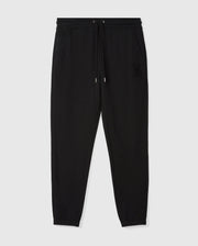 Introducing the MENS PACIFIC CHENILLE JOGGER - B6P972D200 by Psycho Bunny: a sleek pair of black jogger pants designed with an elastic waistband, drawstring, and cuffs. These casual bottoms are adorned with an embroidered logo on the left hip for added style. They are stylishly presented against a light gray backdrop.