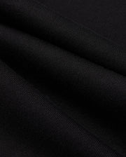 Close-up of black fabric with visible texture and smooth folds, highlighting the fine weave and subtle sheen of the MENS PACIFIC CHENILLE JOGGER - B6P972D200 by Psycho Bunny. Draped to resemble a casual bottom or jogger pant, it creates gentle, flowing lines that emphasize its softness and quality.
