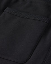 Close-up of a black fabric pocket on the MENS LEVY FLEECE SWEATSHORT - B6R862D200 by Psycho Bunny, showcasing detailed stitching and texture. The pocket features a simple, rectangular design with a small folded edge at the top. The thick and durable fabric appears to be french terry or a similar material.