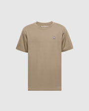 The Psycho Bunny Men's Classic Crew Neck Tee (B6U014CRPC) is a beige short-sleeve shirt with a pink and purple rabbit logo on the left chest. Made from 100% Pima cotton, it features taped seams and the "Psycho Bunny" brand name at the neckline against a plain background.