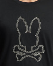 The Psycho Bunny Men's Monarc Front Bunny Graphic Tee (B6U211E200) features a stylized rabbit head with long ears over crossed bones, reminiscent of a classic skull and crossbones design. Made from luxurious Pima cotton, this exclusive black tee combines comfort with edgy style.