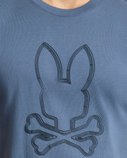 The Psycho Bunny Mens Monarc Front Bunny Graphic Tee (B6U211E200) showcases a 100% Pima cotton fabric with a stitched stylized bunny head and crossed bones in slightly darker blue, adding an irresistibly stylish touch.
