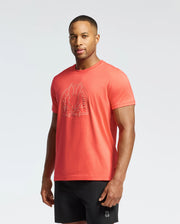 A man wears a red Psycho Bunny MENS MELBOURNE GRAPHIC TEE (B6U410F200) made of Pima Cotton, featuring a bunny logo, paired with black shorts on a plain background.