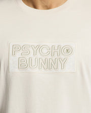 Close-up of the Psycho Bunny MENS SYDNEY WORDMARK GRAPHIC TEE (B6U510F200): light Pima cotton, "PSYCHO BUNNY" in large outlined letters across the chest, with a bunny logo in the "O" and a soft water-based print.