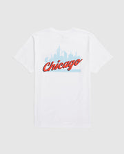 Psycho Bunny's MENS CHICAGO CITY TEE (B6U551W1PC) is a white Pima cotton shirt showcasing a light blue Chicago skyline with "Chicago" in bold, red cursive.