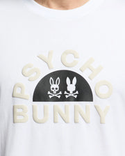 The MENS GOLDIE GRAPHIC TEE by Psycho Bunny is made from luxurious Peruvian cotton, with "PSYCHO BUNNY" in curved block letters and a black semicircle featuring two stylized bunny faces above crossed bones, one with hollow eyes.