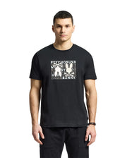 A man is wearing a Psycho Bunny "MENS GOLD COAST GRAPHIC TEE - B6U631F200" in black, made from premium Pima cotton. The classic fit shirt features a graphic bunny design, contrasting with a plain white background.