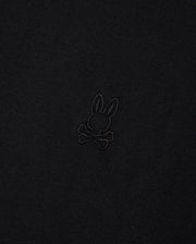 A close-up image of Psycho Bunny's MENS DUKE OVERSIZED TEE - B6U742D200, made from heavyweight Pima cotton fabric featuring an embossed rabbit head with long ears positioned above a pair of crossed bones. The subtle design blends slightly with the fabric, providing a relaxed and comfortable fit.