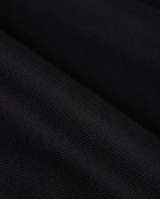 Close-up image of the heavyweight Pima cotton fabric of the Psycho Bunny MENS DUKE OVERSIZED TEE - B6U742D200, showcasing its fine, woven details and subtle lines. The fabric appears to be slightly folded, creating small, diagonal ridges and shadows.