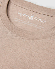 Close-up of the MENS JAMES PREMIUM CREW NECK TEE - B6U952D200 in light brown with a round neckline, made from premium Pima cotton. The label inside the collar reads "Psycho Bunny" with a small bunny logo above and features meticulous embroidery detailing it's 100% Pima Cotton, made in Peru.