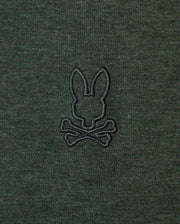 Introducing the Psycho Bunny MENS JAMES PREMIUM CREW NECK TEE - B6U952D200: This premium Pima cotton t-shirt in dark green features an embroidered design of a rabbit's head above crossed bones, reminiscent of a Jolly Roger symbol. The stylish crew neck boasts a design stitched in black thread.