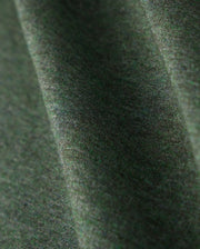 Close-up view of a green fabric with a slight texture and subtle heathered pattern. The premium Pima cotton material appears soft, captured with gentle folds that create a sense of depth. The lighting emphasizes the intricate weave, perfect for the stylish MENS JAMES PREMIUM CREW NECK TEE - B6U952D200 by Psycho Bunny.