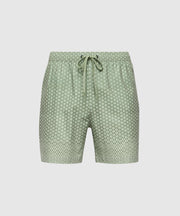 The Psycho Bunny MENS BENDIGO ALL OVER PRINTED SWIM TRUNK (B6W619F200) showcases green shorts with a white geometric bunny pattern, an elastic drawstring waistband, and quick-dry fabric. Displayed on a plain white background.