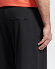 A close-up of a person wearing Psycho Bunny MENS BIG AND TALL LEVANZO EMBROIDERED MICRO FRENCH TERRY SWEATSHORT - B9R578F200, with focus on the back pocket area and their right hand resting by their side.