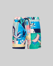 The KIDS BLAISE SWIM TRUNK by Psycho Bunny features vibrant blue, green, yellow, pink, and navy abstract tropical prints with plants, bunny logos, and geometric shapes on a plain gray background with a drawstring waist.