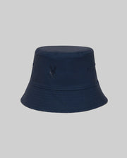 The Psycho Bunny KIDS NAXOS REVERSIBLE BUCKET HAT (KO1500001) features a plain navy blue design, embroidered eyelet vents, and a subtle front logo, displayed against a light gray background.