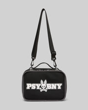 The Psycho Bunny Lunch Box (KO2400002) by Psycho Bunny is black with a top handle, adjustable shoulder strap, and features a white silicone Bunny with skull and crossbones plus "PSYBNY" on the front against a light gray background.