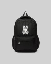 The Psycho Bunny KIDS PSYCHO BUNNY BACKPACK - KO2400004 displays a white cartoon bunny and crossbones emblem on the front pocket. Made from durable canvas with padded, adjustable straps, it is shown on a plain gray background.