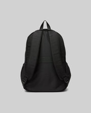 The Psycho Bunny KIDS PSYCHO BUNNY BACKPACK (KO2400004) is shown from the back, highlighting its padded adjustable shoulder straps, top handle, and plain durable canvas design against a light gray background.